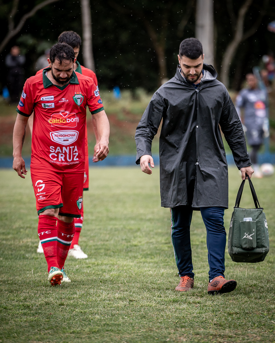 Dr. Victor Hauly acompanhando atleta sob chuva após atendimento